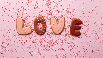 love shaped inscription of sweet biscuits with confetti