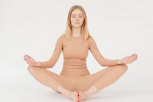 fit young woman sitting in bound angle yoga asana with closed eyes