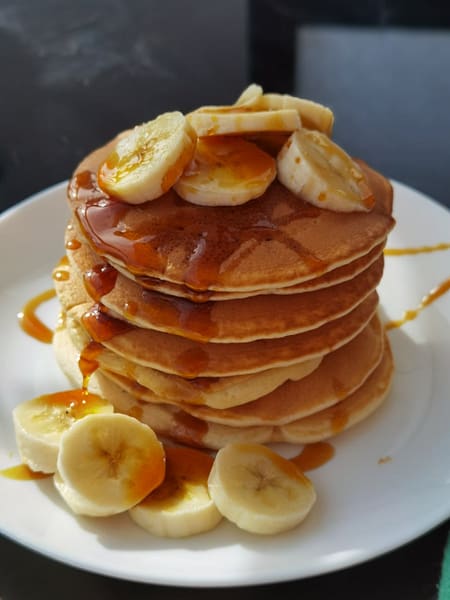 close up photo of pancakes on white plate