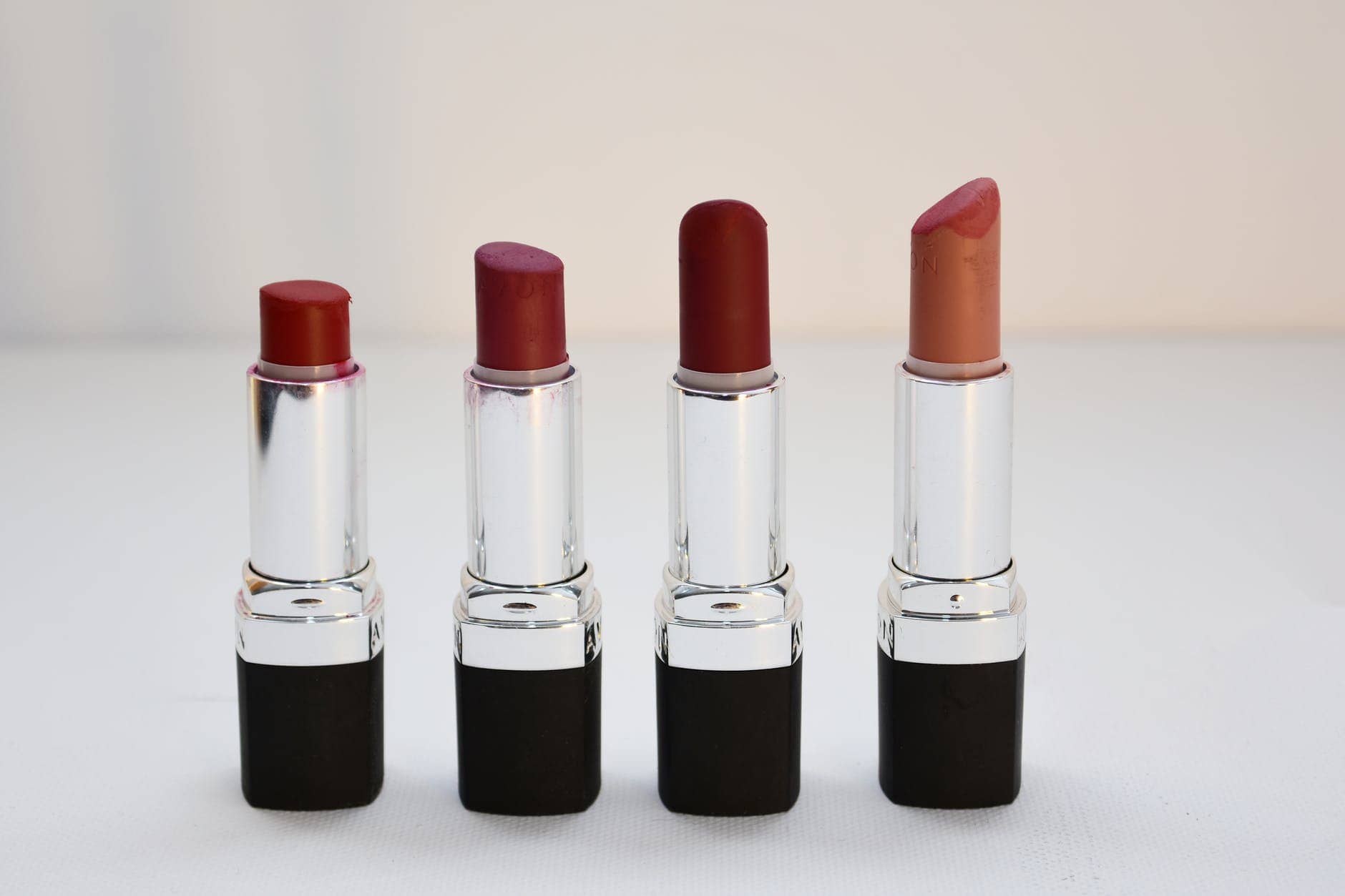 four aligned assorted color lipsticks